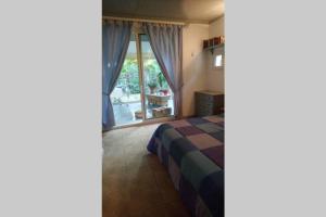 een slaapkamer met een bed en een groot raam bij Maison au calme du village de Chamaret in Chamaret