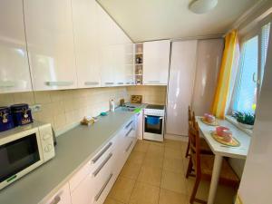 a kitchen with white cabinets and a table and a microwave at 3 Bedroom apartment in the part of the city in Banská Bystrica