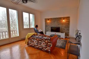 a woman sitting on a couch in a living room at Résidence Les Berges Du Cher in Montluçon