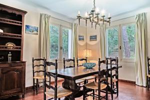 - une salle à manger avec une table, des chaises et des fenêtres dans l'établissement Villa Le Menez Avec Vue Sur Le Lac Marin Pour 10 Personnes, à Hossegor
