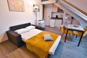 a bedroom with a bed and a table and a kitchen at Résidence Les Berges Du Cher in Montluçon
