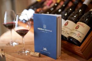 a book and two glasses of wine on a table at Chambre d'hôtes Château Gigognan in Sorgues