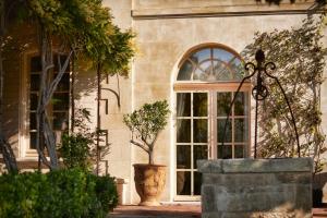 a building with a large window and a potted plant at Chambre d'hôtes Château Gigognan in Sorgues