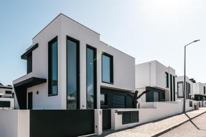 una fila de casas blancas con ventanas negras en Villa Chaves en Óbidos