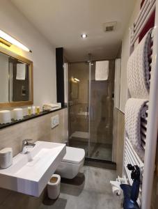 a bathroom with a toilet and a sink and a shower at Hotel Aleo in Bochum