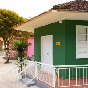 zielony i biały dom z białymi drzwiami w obiekcie Pousada Mama África w mieście Conservatória