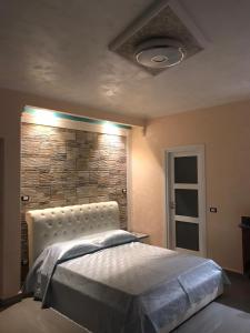 a bedroom with a bed and a brick wall at Guest House Bracciano RM in Bracciano