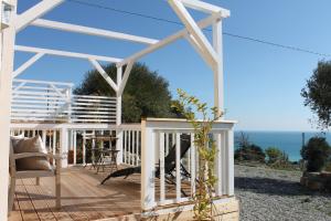 a pergola on a deck with a view of the ocean at Bungalows by B&B Villa Sveva in Rocca Imperiale