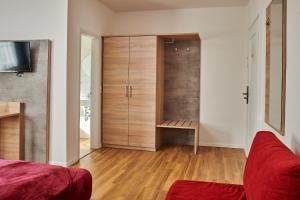 a living room with a closet and a red couch at Zur Allacher Mühle in Munich
