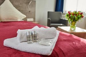 a bed with towels and two perfume bottles on it at Zur Allacher Mühle in Munich