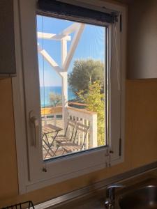 a kitchen window with a view of a balcony at Bungalows by B&B Villa Sveva in Rocca Imperiale