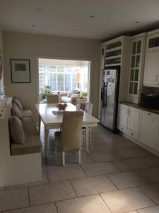 cocina y sala de estar con mesa y nevera en Links Close, Rosslare Strand, Ireland en Rosslare