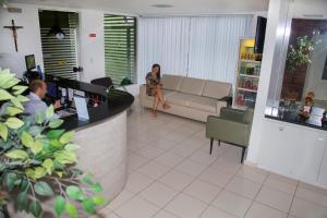Pousada Perola Dourada Maceió في ماسيو: امرأة تجلس على أريكة في غرفة المعيشة