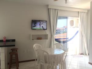 uma sala de jantar com mesa e cadeiras e uma televisão em Kasato Maru Residence em Florianópolis