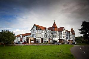 un gran edificio con un campo de césped delante de él en Links Country Park Hotel, en Cromer