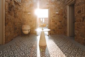 a hallway with a table and a brick wall at Ayiopetra Exclusive Getaways in Káto Sangríon