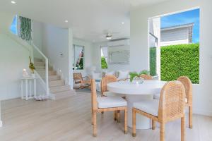 een witte eetkamer met een witte tafel en stoelen bij Garden Grove in Saint James