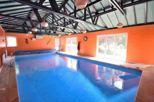ein Hallenbad mit einer orangefarbenen Wand in der Unterkunft Family-Game room-Sleeps 10-Parking-Pets-Bbq in Harlow