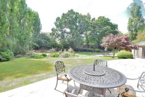 eine Terrasse mit Tisch und Stühlen in einem Hof in der Unterkunft Family-Game room-Sleeps 10-Parking-Pets-Bbq in Harlow