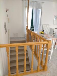 uma escada com um corrimão de madeira e uma janela em Appartamenti vista mare, em Peschici