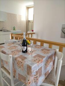 uma garrafa de vinho sentada numa mesa com copos em Appartamenti vista mare, em Peschici