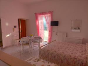 um quarto com 2 camas, uma mesa e uma janela em Appartamenti vista mare, em Peschici
