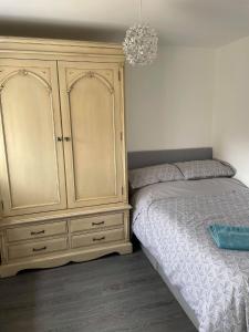 um quarto com uma cama e um grande armário de madeira em Cosy Annexe With Peaceful Surroundings em Upwell
