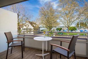 een balkon met een tafel en 2 stoelen en een raam bij Hotel Mediterra in Uhldingen-Mühlhofen