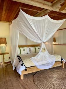 a bedroom with a bed with a canopy at Filha Da Lua Ecolodge in Pipa