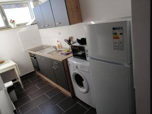 eine Küche mit einem Kühlschrank und einer Waschmaschine in der Unterkunft Wohnung in Troisdorf T02 in Troisdorf