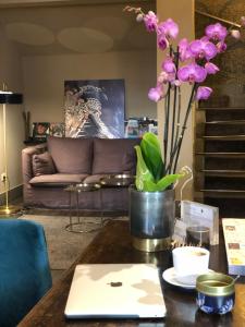 een tafel met een laptop en een vaas met paarse bloemen bij Giuturna Boutique Hotel in Rome