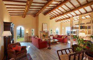 uma ampla sala de estar com mobiliário vermelho e um tecto de madeira em Poggio Tamantino, Villa con piscina in Maremma em Poggio Cavallo