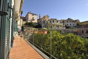 een balkon van een huis met een vrouw op een stoel bij B&B Ca' de Pippu in Diano Castello
