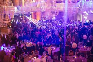 a crowd of people in a banquet hall with chandeliers at Wonderland Cluj Resort in Cluj-Napoca