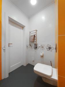 a bathroom with a white toilet and a white door at Antresol in Lviv