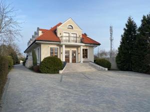 una casa blanca con techo rojo en una entrada en Zielony Dworek, en Częstochowa