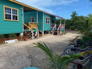 una casa verde con bicicletas estacionadas frente a ella en Lily Pad II, en Caye Caulker