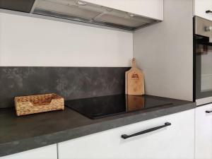 kuchnia z białymi szafkami i czarnym blatem w obiekcie Nuovo elegante appartamento indipendente in Classe A Full Service w mieście Cerro Maggiore +11 zdjęć