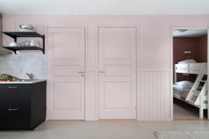 Gärsnäs的住宿－Stockeboda Gård，卧室设有两扇白色门,配有双层床