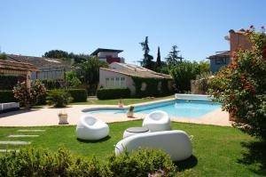 a yard with a swimming pool with white ottomans at MAISON DE CARACTERE POUR 6 PERS AVEC PISCINE in Agde