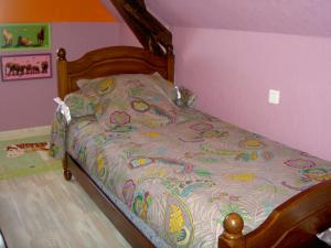 a bedroom with a bed with a colorful bedspread at Gîte Tuyaret in Oloron-Sainte-Marie