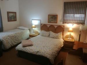 a hotel room with two beds and two lamps at Valley Guest House in Port Elizabeth