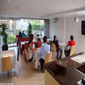 un grupo de personas sentadas en mesas en un restaurante en Hotel Portón Sabaneta, en Sabaneta
