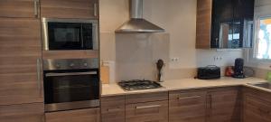 a kitchen with wooden cabinets and a stove top oven at Apartamento de standing Calella de Palafrugell in Calella de Palafrugell