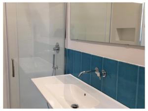 een badkamer met een witte wastafel en een spiegel bij Elefante appartamenti in Pescara