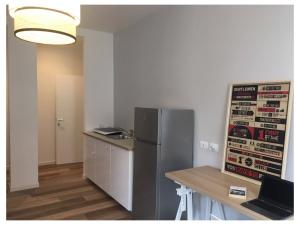 een keuken met een koelkast en een tafel met een laptop bij Elefante appartamenti in Pescara