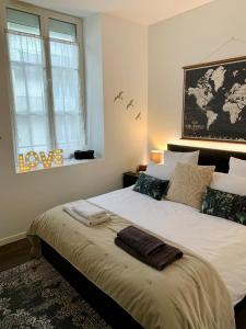 - une chambre avec un grand lit blanc et une fenêtre dans l'établissement Le Servannais, à Saint-Malo