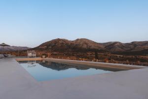 a swimming pool with mountains in the background at Ayiopetra Exclusive Getaways in Káto Sangríon