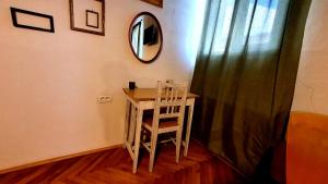 Camera con scrivania, specchio e sedia di Nomad Apartment Braşov a Braşov
