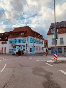 un bâtiment bleu et blanc au coin d'une rue dans l'établissement Gästehaus Kronenstraße, à Schwetzingen